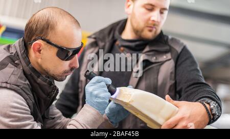 Technicians use UV lamp light for curing resin 3d print printed on modern 3d printer machine Stock Photo