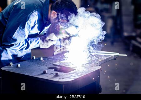 worker welding metal working in steel heavy industry manufacturing. Stock Photo