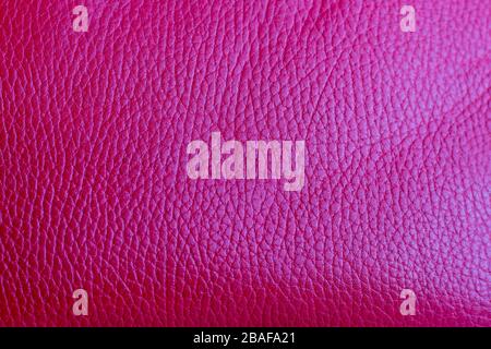 Genuine bright pink leather. Texture of the leather bag surface. Light reflection. Fashion accessory of genuine leather. Stock Photo