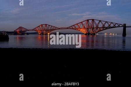 Lighted Forth railway bridge across the Firth viewed from South Queensferry by night in winter, Scotland, UK, Europe Stock Photo