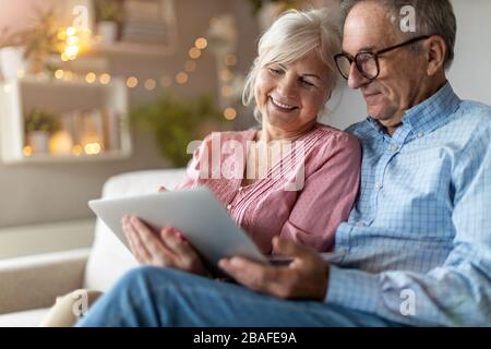 Mature couple using a laptop while relaxing at home Stock Photo