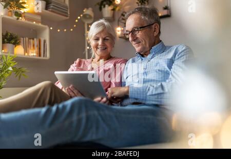Mature couple using a laptop while relaxing at home Stock Photo