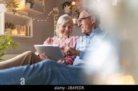 Mature couple using a laptop while relaxing at home Stock Photo