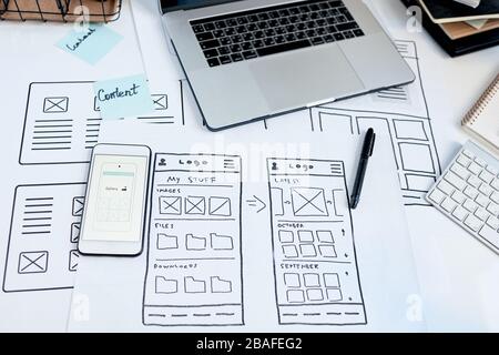 Close-up of workplace of user interface designer creating usable application for devices, sketches and smartphone on table Stock Photo