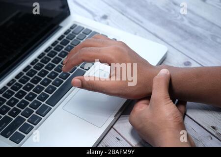 man holding her wrist pain from using computer. Office syndrome Stock Photo