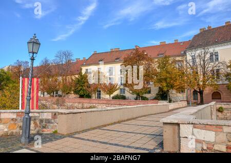 Budapest, Hungary - Nov 6, 2019: Beautiful street in the historical old town of Hungarian capital city photographed with autumn trees. Historical buildings, no people. Eastern European town. Stock Photo