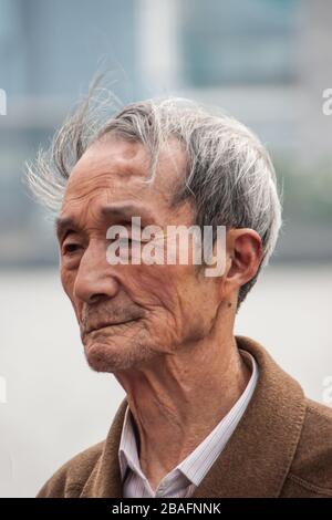 Shanghai, China - May 4, 2010: Closeup of face of older graying senior man with cloths featuring white and brown around neck. Stock Photo