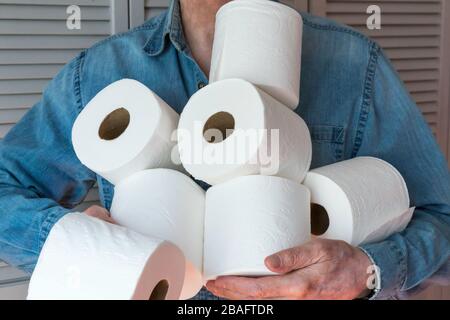 Man holding extra rolls of toilet paper during Coronavirus pandemic, USA Stock Photo