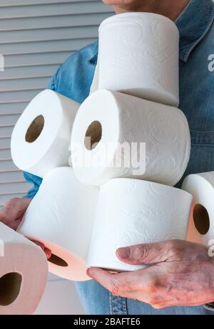 Man holding extra rolls of toilet paper during Coronavirus pandemic, USA Stock Photo