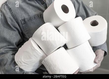 Man holding extra rolls of toilet paper during Coronavirus pandemic, USA Stock Photo