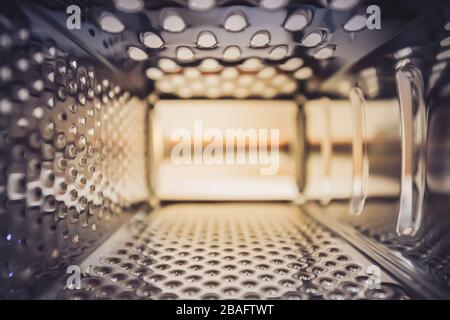 close up inside a metal cheese grater kitchen tool, shiny Stock Photo