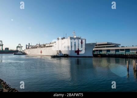 In this photo released by the United States Navy, the Military Sealift Command hospital ship USNS Mercy (T-AH 19) arrives in Los Angeles, California, March 27, 2020. Mercy deployed in support of the nation's COVID-19 response efforts, and will serve as a referral hospital for non-COVID-19 patients currently admitted to shore-based hospitals. This allows shore base hospitals to focus their efforts on COVID-19 cases. One of the Department of Defense's missions is Defense Support of Civil Authorities. DoD is supporting the Federal Emergency Management Agency, the lead federal agency, as well as s Stock Photo