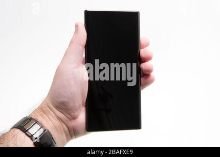 Hand held generic phone over white, black smartphone Stock Photo