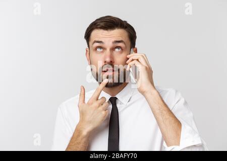 Angry and serious businessman talking on the phone over gray background Stock Photo