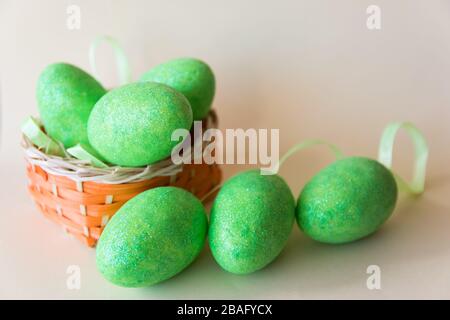 Easter green eggs in the basket on beige background. Easter concept. Spring time. Stock Photo