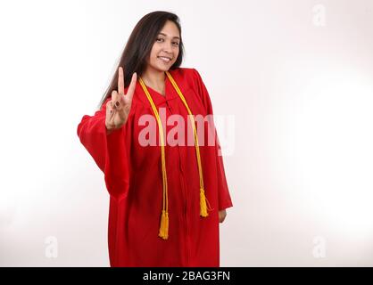 A graduating student holds up a peace sign. Stock Photo
