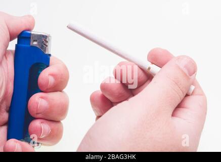 Fire lighter in hand and cigarette Stock Photo