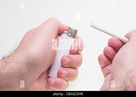 Man lights a cigarette isolated on white Stock Photo