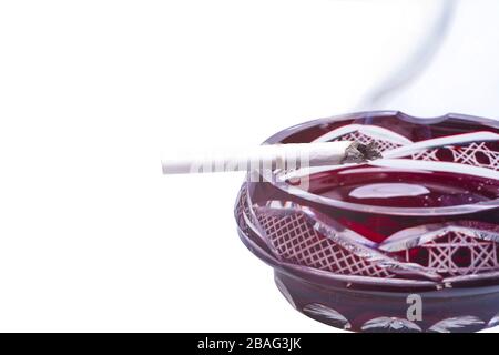Burning cigarette on ashtray isolated over a white background Stock Photo
