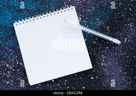 Blank spiral notebook with copy space for text on abstract dark blue background. Planning concept. White paper page and pen, empty sheet, mockup Stock Photo