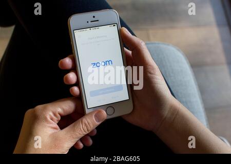 A woman opening the Zoom mobile app on her phone. Zoom users can opt to record sessions, collaborate on projects, and annotate onone another's screens. Stock Photo