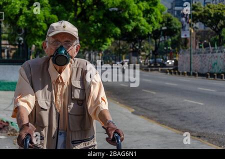 An older man wears a leather mask and gloves to protect himself. The coronavirus arrived in Venezuela. This was confirmed by the country's vice presid Stock Photo