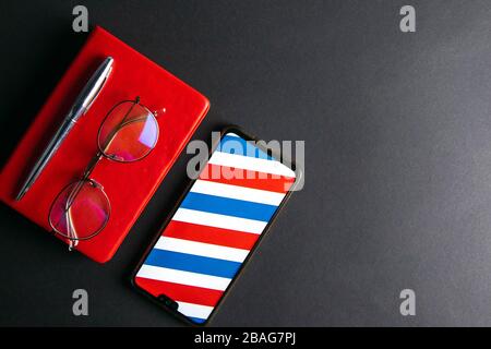 Photo of Smart phone, note book, eye glasses pen on a black background Stock Photo
