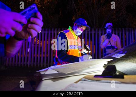 Cape Town, South Africa. 27th Mar, 2020. CAPE TOWN, SOUTH AFRICA - Friday 27 March 2020: a Law Enforcement officer of the City of Cape Town, writes out a fine after pulling over a driver at a roadblock to ensure that non-essential vehicles are not on the road. The President of South Africa, Mr Cyril Ramaphosa, declared a 21 day national lockdown to combat the rapidly spreading COVID-19 virus, or Coronavirus. The public are required to stay at home during this period. Credit: Roger Sedres/Alamy Live News Stock Photo