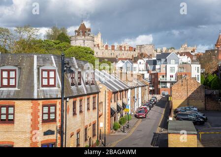 View from above of a street lined with traditional terraced houses in a town centre under stom clouds on a spring day