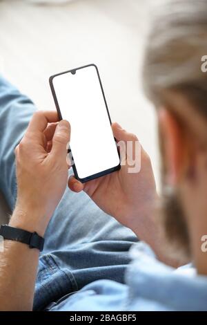 Man using smart phone mock up white screen, over shoulder vertical view. Stock Photo