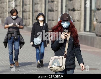 People wearing protective face masks as a preventive measure against the COVID-19 coronavirus walk in Kiev.The Ukrainian Government introduced a national emergency for 30 days and extends the quarantine against the spread the COVID-19 coronavirus in Ukraine till 24 April 2020. As of 10:00 am on 27 March 2020 there were 218 laboratory confirmed COVID-19 cases in Ukraine, of which 5 were lethal and 4 were recovering. During the day, 62 new cases were recorded in Ukraine. Stock Photo