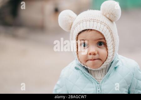 Little baby boy in winter wear with fluffy ears on knitted hat. Cute child  Stock Photo