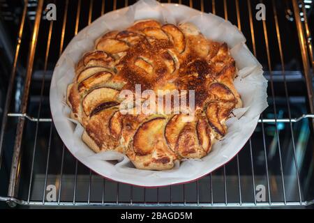 Freshly baked apple pie at home in the oven in the kitchen. Apple Charlotte Homemade baking. Vegan cake in a baking dish Stock Photo