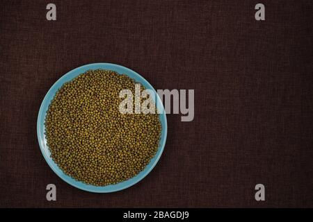 Organic mung beans on blue ceramic dish over canvas background Stock Photo