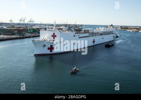 In this photo released by the United States Navy, the Military Sealift Command hospital ship USNS Mercy (T-AH 19) arrives in Los Angeles, Calif., March 27, 2020. Mercy deployed in support of the nation's COVID-19 response efforts, and will serve as a referral hospital for non-COVID-19 patients currently admitted to shore-based hospitals. This allows shore base hospitals to focus their efforts on COVID-19 cases. One of the Department of Defense's missions is Defense Support of Civil Authorities. DOD is supporting the Federal Emergency Management Agency, the lead federal agency, as well as state Stock Photo