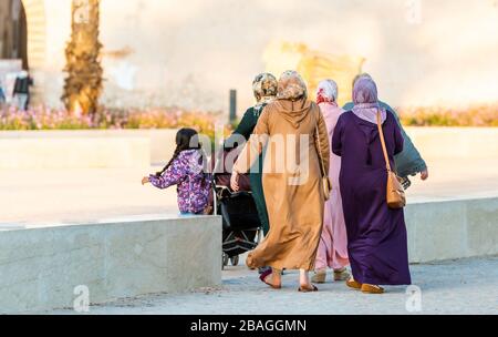 Women in typical moroccan clothes on a city street, Essaouira, Morocco. Back view Stock Photo