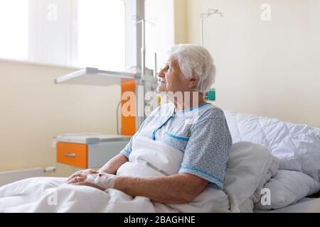 Senior patient in hospital bed Stock Photo