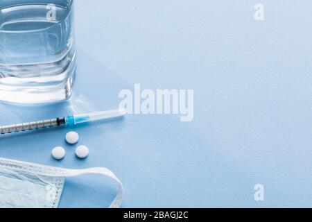 Syringe with pills, water and surgical mask Stock Photo