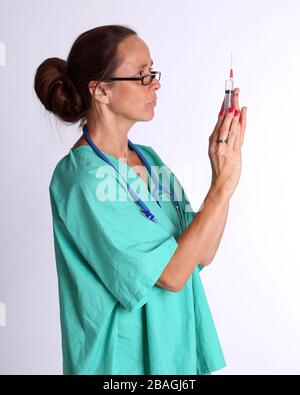 August 2015 - Older lady doctor returning to duty to serve too assist with the treatment of Coronavirus patients Stock Photo