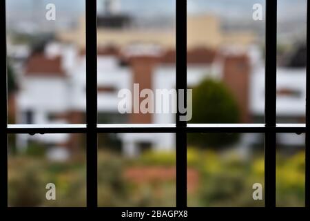 A rainy day behind the window bars at home due to the coronavirus pandemic Stock Photo