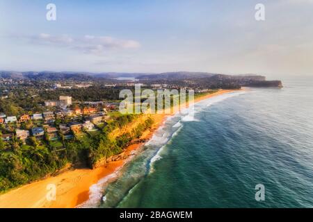 Ocean coastline of Sydney northern beaches in elevated aerial view over rolling waves and yellow sandy beaches. Stock Photo