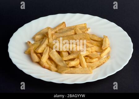 White plate on black background with large and small fries Stock Photo