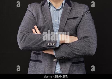A man in a jacket shows clasped hands. Closed pose. Close up. Stock Photo