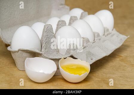 Paper Egg Tray with white eggs. chicken white eggs close up. beige background. broken chicken white egg. Stock Photo