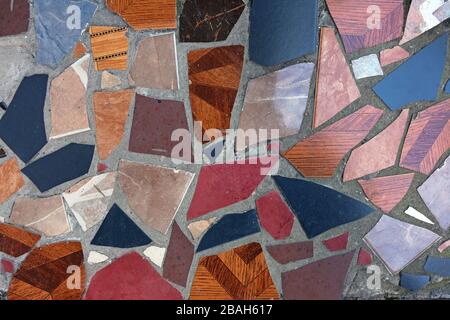 Fragment of a floor from pieces of a multi-colored tile background. The original path made of cement and tile pieces in Georgia. Stock Photo