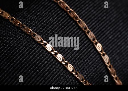 Gold chain on black fabric. Close up. Stock Photo