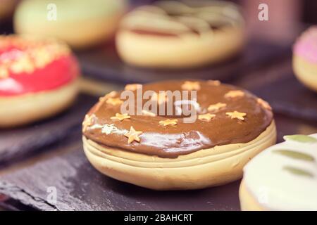 Donuts on stone utensils in a display case. Close up. Stock Photo