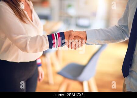 Two middle age business workers working together doing handsake at the office Stock Photo