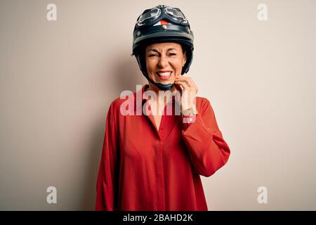 Middle age motorcyclist woman wearing motorcycle helmet over isolated white background touching mouth with hand with painful expression because of too Stock Photo