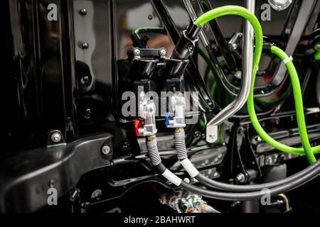 Back wall of a black industrial tractor cab with high-pressure connecting hoses and connecting devices with valves for the correct operation of big ri Stock Photo